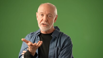POV of mature man with a beard gestures expressively while standing against a solid green screen...