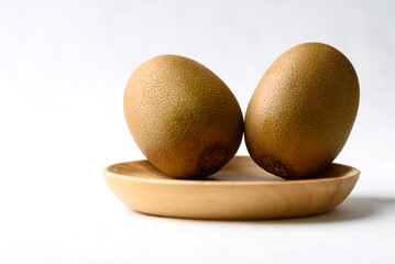 Fresh kiwi fruit on wooden plate with white background, Healthy fruit