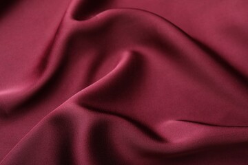 Fototapeta premium Crumpled burgundy silk fabric as background, closeup