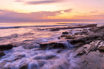 Photo of the surf at a rocky beach just before sunrise at Marineland, Florida