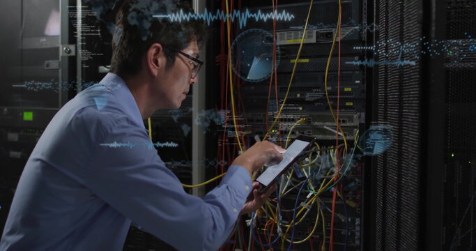 Examining wiring, IT technician using tablet in data center, network racks, cables, copy space