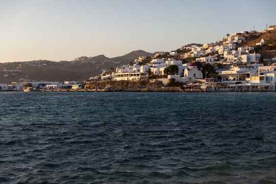 Fototapeta View of Mykonos coastline from a yacht in early evening golden light. 