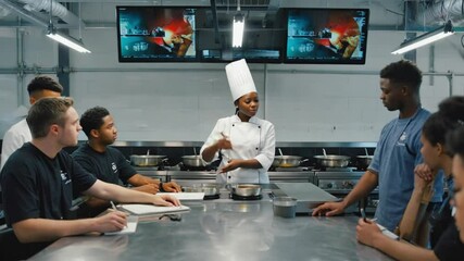 Chef Explaining Cooking Class to Students in Kitchen Studio