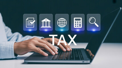 Corporate Business Image Typing Hands on Dark Laptop with Floating Blue Digital Symbols and ‘TAX’ Text Highlight
