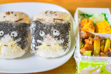 ラップを巻いた猫型のおにぎり弁当