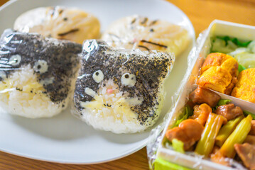 ラップを巻いた猫型のおにぎり弁当