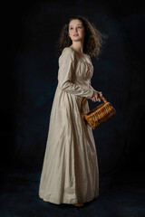 A Regency woman wearing a cotton dress with her long hair blowing in the wind against a studio...