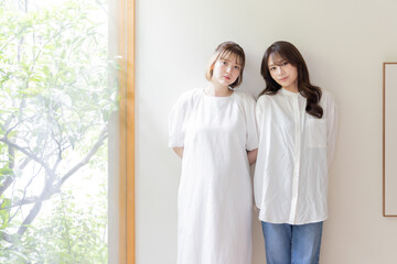 壁にもたれる二人の女性