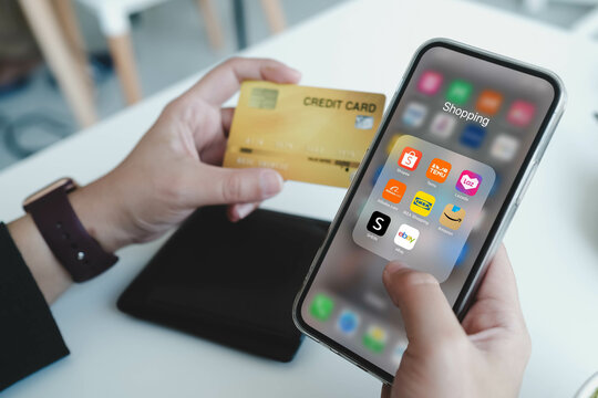 Bangkok, Thailand. June 30, 2025; A person holding a credit card and a smartphone displaying a folder of popular e-commerce apps like Shopee, Lazada, Amazon, Alibaba, and eBay.