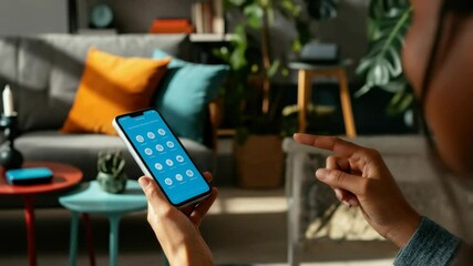 African-American woman using smartphone for video call, relaxed setting - Powered by Adobe