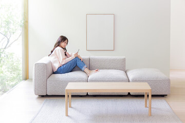 ソファーでスマホを使う女性