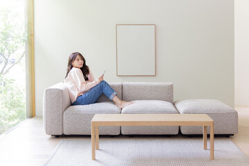 ソファーでスマホを使う女性