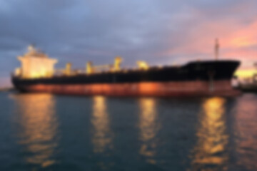 Fototapeta premium blurry photo of giant tanker ship docked at port to transport oil from land, sunset, energy.