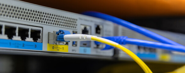Network cables connected to switches. Fiber Optical cables connected to an optic ports and Network...