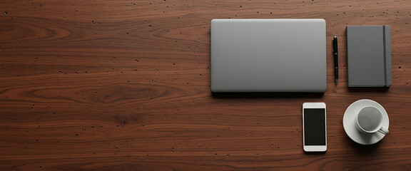 Organized desk setup with closed laptop, smartphone, notebook, pen, and ceramic coffee cup on a dark rustic wooden surface. Balanced layout with clean professional vibe.