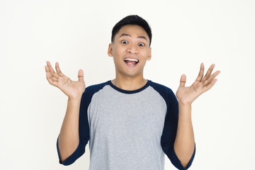 Young man in a gray shirt enthusiastically gesturing, showing excitement and joy on a white background.