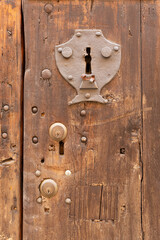 Fototapeta premium Old metal keyhole surround embedded into a weathered wooden door