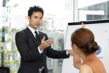 Business Presentation. A professional man presenting data on a flip chart during a meeting.