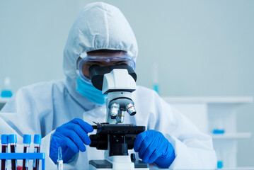 Scientist man look into Microscope research in science laboratory. Asian scientist look at...