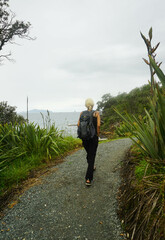 a woman walking around Waipu pancake rocks in Waipu, New Zealand.