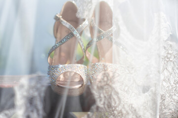 Sparkling bridal high heels captured behind a delicate lace veil. Elegant and romantic detail from...