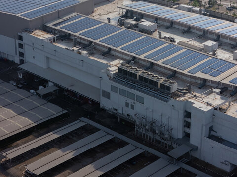 Cooling towers in data center building. Air conditioning cooling towers in front of building with fins to the front. Industrial cooling towers or air cooled water chillers with piping system.