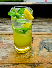 view of a glass of lime ice with mint leaves and lemon topping