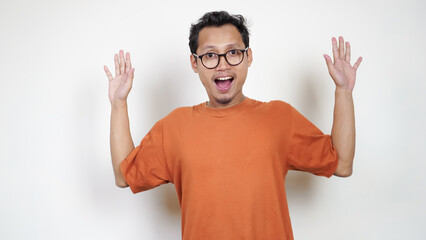 A man in an orange shirt is smiling and waving