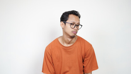 A man wearing glasses and an orange shirt is looking at the camera