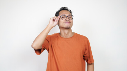 A man in an orange shirt is smiling and pointing to the camera