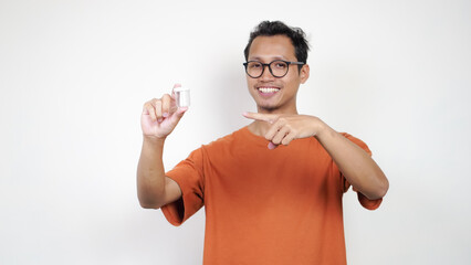 A man in an orange shirt is holding a clear container