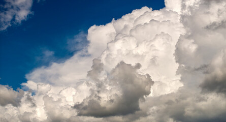 Blue sky with white summer rain clouds. Colorful summer landscape