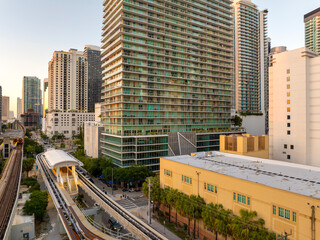 View from above of public train passing through downtown railroad of Miami, Florida, USA. Financial...
