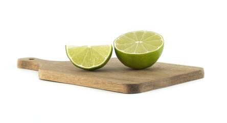 Fresh lime cut in half and slice on wooden cutting board