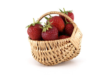 Fresh strawberries overflowing a small wicker basket