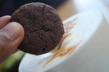 Enjoying a chocolate cookie with coffee 