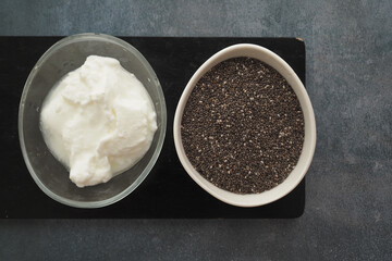 Chia seeds and yogurt displayed on wooden table