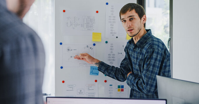 Team adult male engineer develop present AI robotics hand project at tech workspace. Artificial intelligence, collaboration support prototype development, robotic, debugging, machine learn, training.