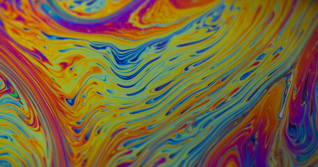 Fuel spilling. Iridescent art. Blur yellow blue purple color flowing chemical paint water floating...