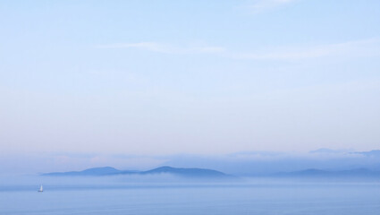 Mountain landscape with alpine meadow and colorful forest at sunset.