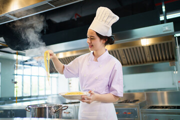 Caucasian girl enjoy with her cooking in a kitchen. Girl boiling a spaghetti.