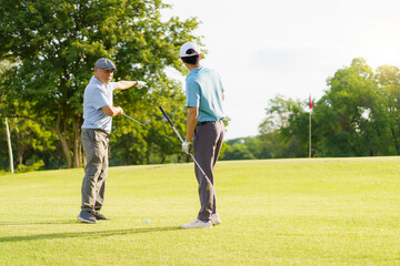 Asian man and elderly father are enjoy playing golf together with a good time.