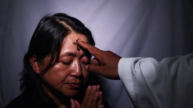 ash cross on woman forehead in ash wednesday celebration