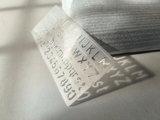 Clear Plastic Alphabet and Number Stencil on Reflective Surface