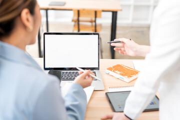 Mockup image of a two woman using laptop with blank screen on wooden table