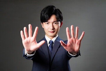 ビジネスマン　止めるジェスチャー　黒背景