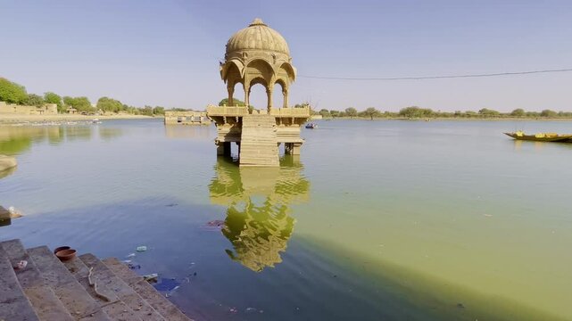 Gadsisar Lake in Jaisalmer glistens under the Rajasthan sun, reflecting ancient temples and serene pavilions. Golden light, calm waters, and migratory birds enrich its timeless desert charm