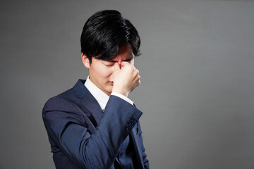ビジネスマン　眼精疲労　黒背景