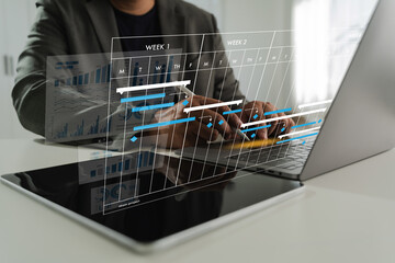 Project management software person working laptop with digital graphs and charts overlay, analyzing data and schedules modern office setting