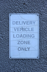 Delivery Vehicle Loading Zone Only sign mounted on the wall of a building